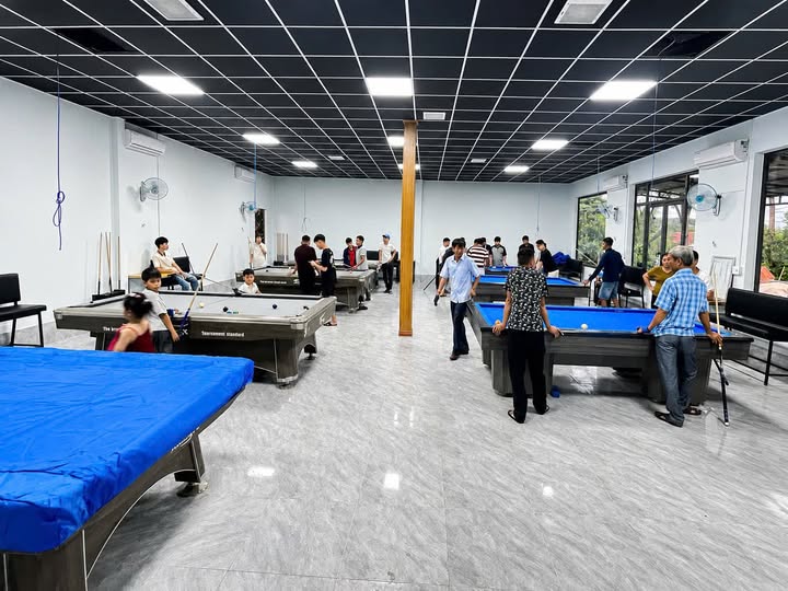 Không gian câu lạc bộ bida với nhiều bàn và người chơi