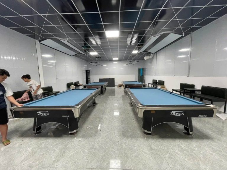 Các bàn Pool vải xanh trong phòng với người chơi bên bàn
