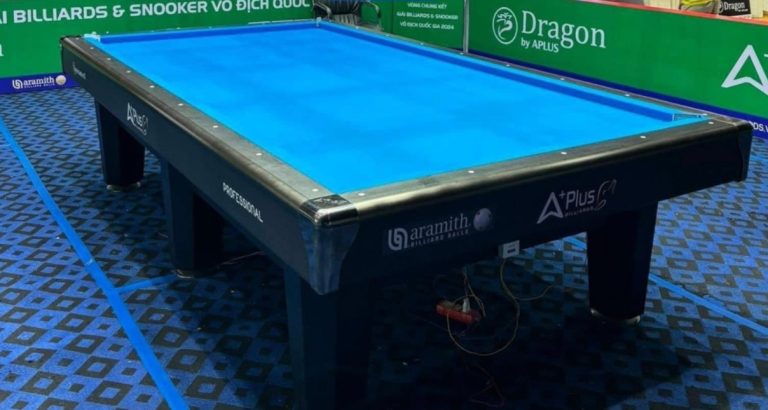 Góc nghiêng bàn bida Aplus Carom Gen 2 với mặt chơi xanh và thành bàn tối màu