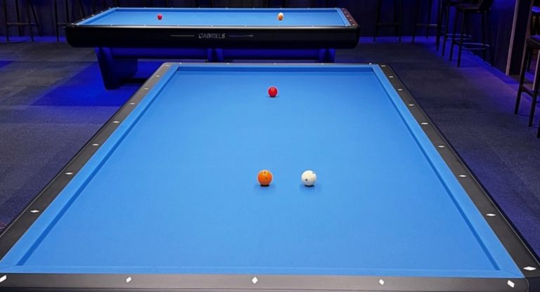 Mặt chơi Gabriels Rafale 2.0 nhìn từ trên xuống với ba quả bi Carom trên nỉ xanh